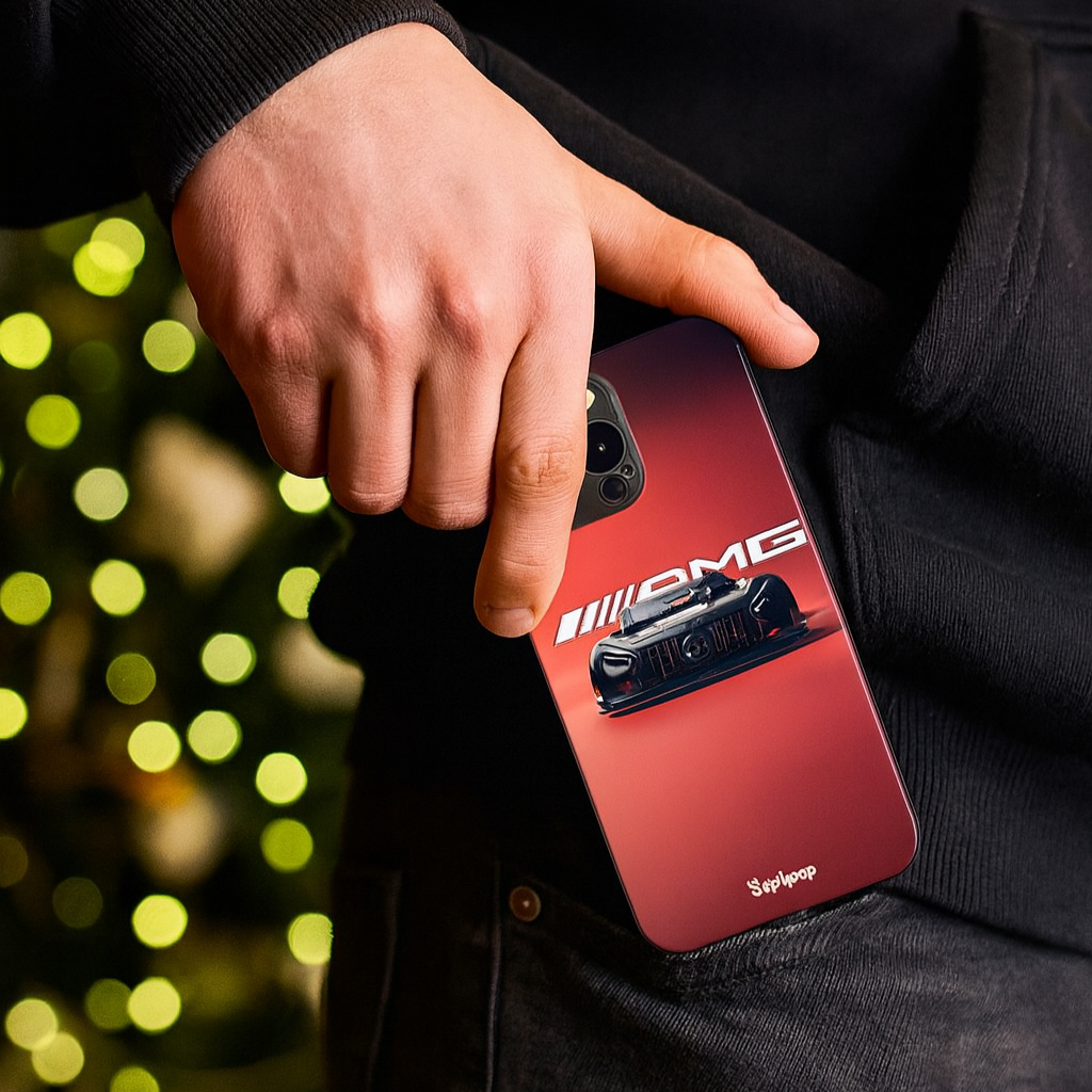 Person holding a red phone case with AMG logo against a blurred green light background